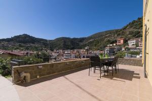 a balcony with a table and chairs and a city at Villa Lepanto Nafpaktos in Nafpaktos
