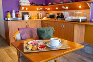 a table with a plate of food and a cup of coffee at Hotel Aguado in Dieppe