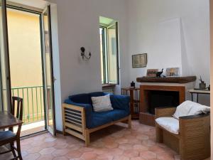 a living room with a blue chair and a fireplace at La luce del borgo in Castel Gandolfo