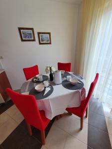 a dining room table with red chairs and a black and white table at Lavanda Samarin in Zambratija