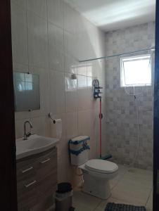 uma casa de banho com um WC, um lavatório e uma janela em CHÁCARA TERRA dos SONHOS em Guaratinguetá