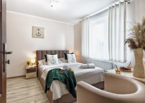 a bedroom with a bed and a table and a chair at Willa Kapitańska i Willa Marynarska in Łeba