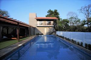 a house with a swimming pool in front of a house at Privystays Jk's Private Villa in Alibaug