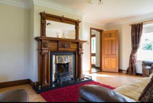 a living room with a fireplace and a mirror at Corraglass House - close proximity to Cuilcagh in Letterbreen