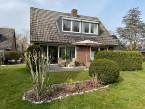 a house with an umbrella in a yard at Ferienwohnung Idylle auf Fehmarn I in Vitzdorf