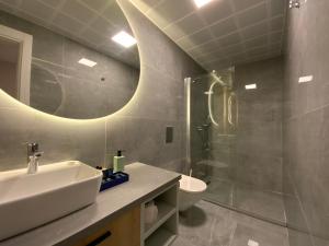 a bathroom with a sink and a toilet and a mirror at KADAGAN SUİTES AYASARANDA in Çeşme