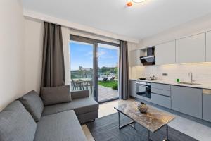 a kitchen and living room with a couch and a table at KADAGAN SUİTES AYASARANDA in Çeşme