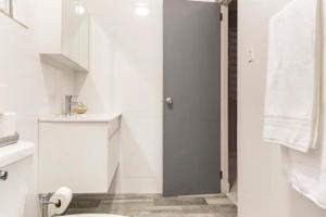 a white bathroom with a toilet and a sink at Latitude Adjustment in San Juan