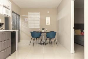 a dining room with a table and blue chairs at Latitude Adjustment in San Juan