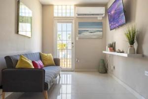 a living room with a couch and a tv at Latitude Adjustment in San Juan