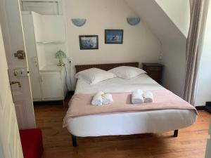 1 dormitorio con 1 cama con toallas en Le Pourquoi pas en La Bourboule