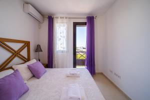 a bedroom with a bed and a window with purple curtains at Villa Turquesa in Playa Blanca +24 photos