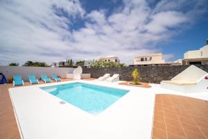 a villa with a swimming pool and chairs at Villa Turquesa in Playa Blanca