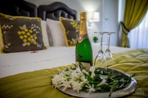 ローマにあるシック & タウン ラグジュアリー ルームズのベッドにシャンパン1本と花皿