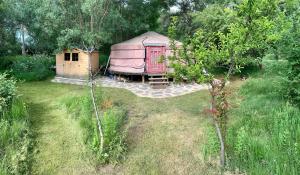 a yurt with a house in the middle of a yard at La Yurta de Gaia in San Lorenzo de El Escorial