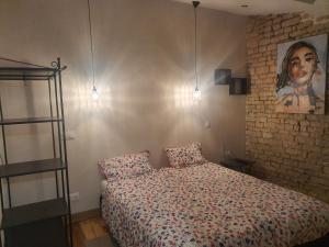 ein Schlafzimmer mit einem Bett und einem Wandgemälde in der Unterkunft La P'tite Écurie in Saint-Jean-de-Liversay