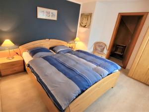 1 cama grande con sábanas azules en un dormitorio en Gästehaus Bei J.A.G., en Büsum