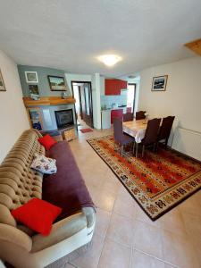 Apartments & rooms Velebit في Lovinac: غرفة معيشة مع أريكة وغرفة طعام