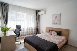 een slaapkamer met een bed, een stoel en een raam bij Black Sea Top Centre Apartments in Varna