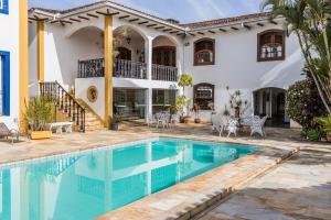 a villa with a swimming pool and a house at Pousada Casarão in São João del Rei