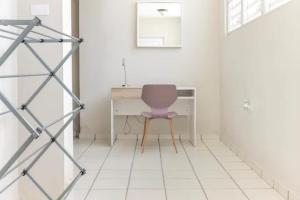 a desk with a purple chair in a white room at Latitude Adjustment in San Juan