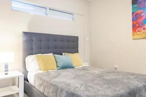 a bedroom with a large bed with yellow and blue pillows at Latitude Adjustment in San Juan