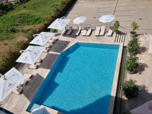 an overhead view of a swimming pool with chairs and umbrellas at Golden Ring Resort in Tirana