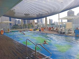 a pool on the top of a building with people in it at YalaRent Midtown towers TLV in Tel Aviv