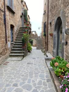 an alley in an old town with flowers and stairs at L'Incanto di Civita in Bagnoregio