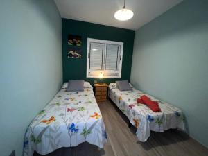 two beds in a room with green walls at Hostal-Private Room Descanso y Relax in Puerto del Rosario