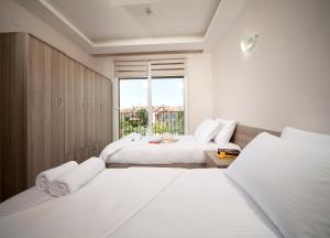 1 dormitorio blanco con 2 camas y ventana en İNDAĞ APART AİLE Oteli, en Seferihisar