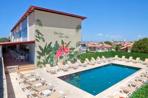 a resort pool with lounge chairs and a mural at İNDAĞ APART AİLE Oteli in Seferihisar