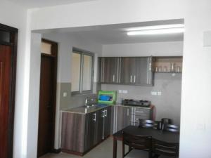 a kitchen with a sink and a table with a tablektop at Shanzu Beach apartment with stunning Ocean view in Mwakirunge