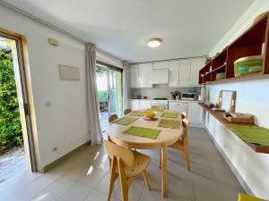 uma cozinha com uma mesa de madeira e cadeiras em The Cliffs - Bungaleiro de Area em Viveiro