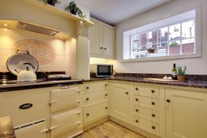 uma cozinha com armários brancos e uma janela em 10 Westgate Street Southampton em Southampton