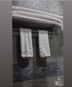 un grupo de toallas colgando de un estante en el baño en flamingo hotel irbid, en Zabdah