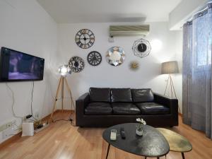 バルセロナにあるBarcelonaforrent Sant Pau Barcelona Suitesのリビングルーム(黒いソファ、テーブル付)