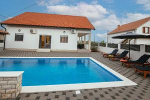a villa with a swimming pool and a house at Family house Moja jube in Oklaj