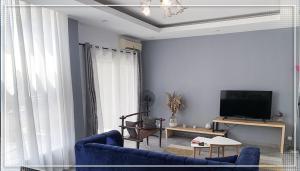 uma sala de estar com um sofá azul e uma televisão em Nalabba em Dakar