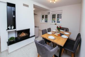 a dining room with a table and a fireplace at Family house Moja jube in Oklaj