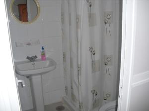 a white bathroom with a sink and a shower at Pension El Guanche in Frontera