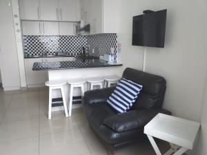 a living room with a couch and a kitchen at Afsaal 410 Holiday flat in Amanzimtoti
