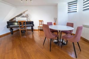 a dining room with a table and a piano at Apartment Porin in Velika Gorica