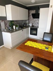 a kitchen with white cabinets and a wooden table at Donna in Vrh