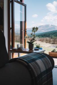 a room with a couch and a window with a view at Frances' Sketch Pad with Hot Tub in Fort William