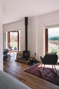 a living room with a chair and a fireplace at Frances' Sketch Pad with Hot Tub in Fort William