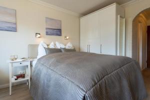 a bedroom with a large bed and a white cabinet at Haus-Schwanensee-Wohnung-27-Kajaknutzung-inklusive in Bosau