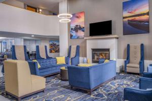 vestíbulo con sofás azules, chimenea y TV en La Quinta by Wyndham Minneapolis-Minnetonka, en Minnetonka