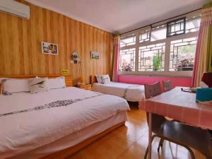 延庆县Beijing Badaling Great Wall Caos Courtyard Hostel 1VIP service 2Ancient style Chinese yard 3 only 15 minutes walk to the Badaling Great Wall 4 be your free advisor 5 offer private guided tour 6 experience local food and culutre的有两张床和一扇窗户的酒店房间