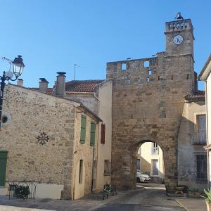 an old stone building with a clock tower at Maison Agnes et Johann in Sauvian
